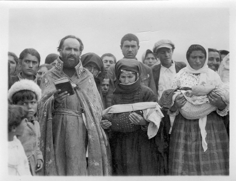 Priest performing a baptism ritual for refugees