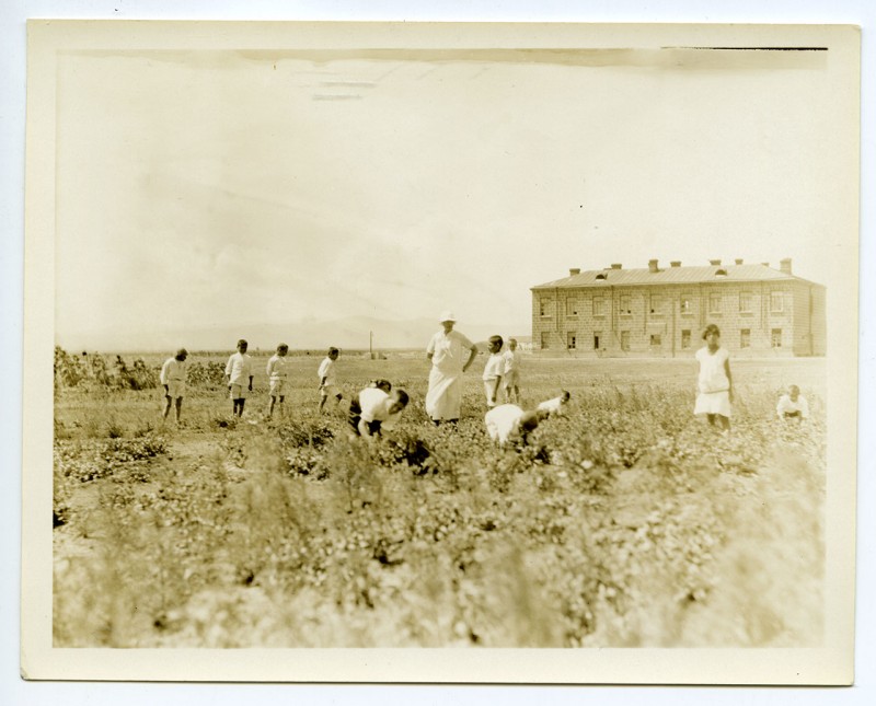 Children and a relief worker in the orphanage garden.