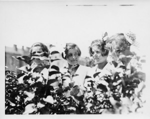 Older girls standing behind tall plants in the garden at Kazachi Post, Alexandropol