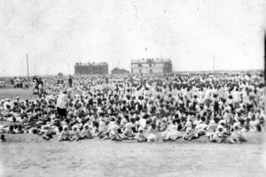 Large group of children in front of Alexandropol barracks. A relief worker is visible on the lefthand side.