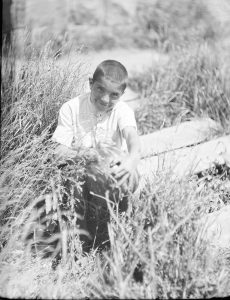 A boy holds a watermelon grown in the orphanage garden. Probably Alexandropol. 